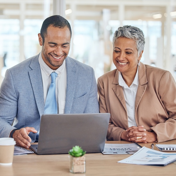 Financial advisors using a laptop to create digital ads
